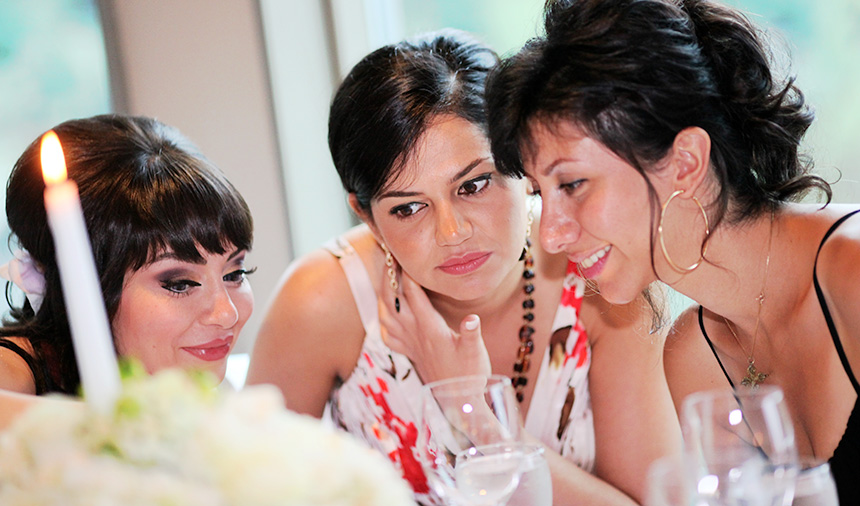 Pretty girls check out photos at the wedding reception on Grouse Mountain wedding day